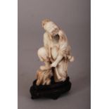 C17th/18th Chinese soapstone figure of Daoist immortal, holding a peach in his mouth, wearing long