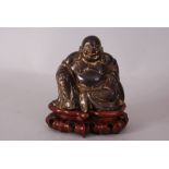 C19th/20th Chinese gilt-bronze figure of Buddha, modelled seated and wearing loose robes open at the