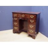 Mahogany kneehole desk on square bracket feet, with central cupboard flanked by 3 side drawers below