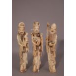 Set of three C18th/19th Chinese ivory figures of immortals, the first holding a fruiting peach and a