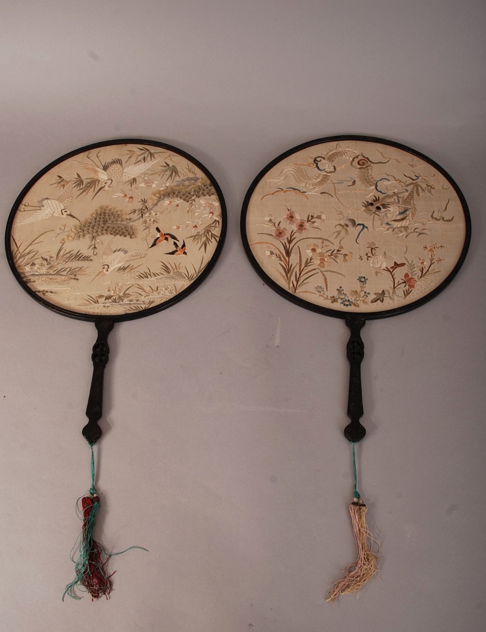 Two C19th Chinese silk circular fans, each mounted in a lacquered-wood frame with handle, one