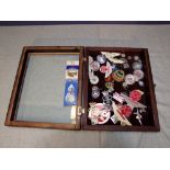 Table top display case containing Aston Martin & Mercedes Benz lapel badges, grille & bodywork