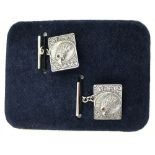 Pair of silver cufflinks depicting birds of prey