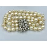 Triple strand pearl bracelet with diamond clasp set within brilliant cut, baguette and marquis cut