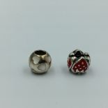 2 silver Pandora charms 1 with hearts 1 with strawberries