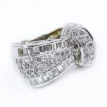 Round Brilliant Cut and Baguette Diamond and 18 Karat White Gold Ring. Stamped 18K. Very good