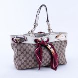 Gucci Beige Supreme Monogram Canvas And Leather Positano PM Tote. Gold tone hardware. The interior