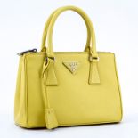 Prada Yellow Small Grained Leather Saffiano Lux Handbag. Silver tone hardware, the interior of sign