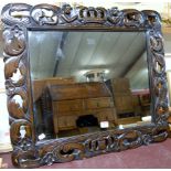 A carved and stained beechwood framed rectangular wall mirror,