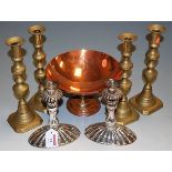 A pair of silver plated candlesticks raised on reeded domed bases,