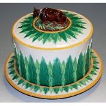 A Victorian George Jones majolica cheese dome on stand, the cover surmounted by a recumbent cow,