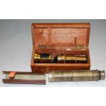 An early 20th century brass monocular microscope housed in a fitted box,