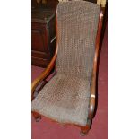 A Victorian mahogany and upholstered scroll armchair raised on turned supports