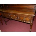 An early 20th century Jacobean style moulded oak ledgeback three drawer sideboard raised on turned