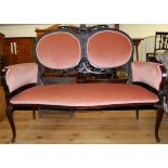 An Edwardian walnut and pink upholstered two seater salon settee,