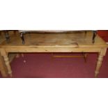 A modern pine round cornered farmhouse style kitchen table on turned supports,