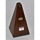 A mid 20th century French walnut cased metronome bearing a label for Paquet,