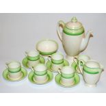 An Art Deco Royal Doulton coffee service, on a pale cream ground with lime green borders,