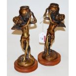 A pair of reproduction bronzed figural candlesticks,