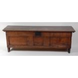 A large early 18th century oak coffer, the hinged lid with iron strapwork hinges,