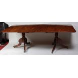 A Regency mahogany twin pedestal dining table, the top having a moulded edge, drop-in leaf,