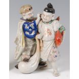 A Japanese late Meiji period stoneware figure group of a pair of street-vendors,