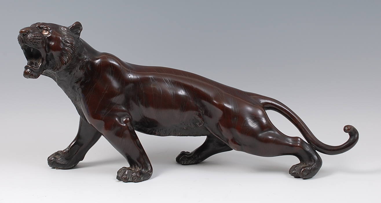 A Japanese Meiji period bronze tiger, naturalistically modelled in growling pose,