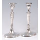 A pair of Edwardian silver candlesticks, in the Adam style,