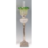 A silver plated Corinthian column pedestal oil lamp, having green tinted and acid etched shade,