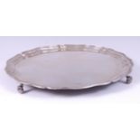 A George V silver salver, having a raised piecrust rim and on scroll feet, 41oz,