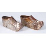 A pair of early 20th century Dutch silver miniature clogs, each embossed with figure scenes,
