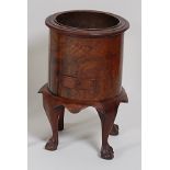 A circa 1900 figured walnut wine cooler, of cylindrical form,