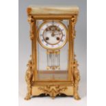A circa 1900 French gilt bronze four glass mantel clock, having an onyx top,