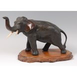 A Japanese Meiji period bronze elephant, naturalistically modelled with raised trunk,