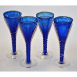 A set of four contemporary blue glass wine glasses, each of conical form,