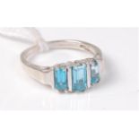 A 9ct white gold three stone topaz ring, the three graduated step cut topaz,