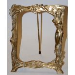 An Art Nouveau style cast brass easel photograph frame, decorated with robed maiden within foliage,