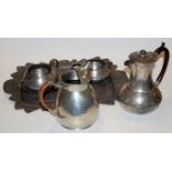 An Arts & Crafts spot hammered pewter three piece tea service together with an associated hot water