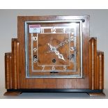 An Art Deco walnut cased mantel clock having silvered Arabic numerals,