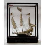 A mid 20th century Chinese white metal model of a Chinese sailing junk in a glazed display case,