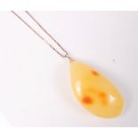 A large butterscotch amber pendant, 6cm long (approx. 16.