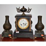 A late Victorian black slate mantel clock having enamelled dial with Roman numerals and eight day