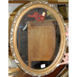 A pair of gilt plaster moulded oval wall mirrors;