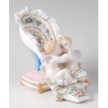 A 19th century Dresden porcelain cherub and shoe posy vase, the heel upon a pin cushion,