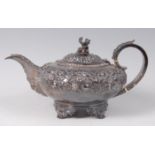 A George IV teapot, of squat circular form, the shoulders with leaf and flower chased decoration,