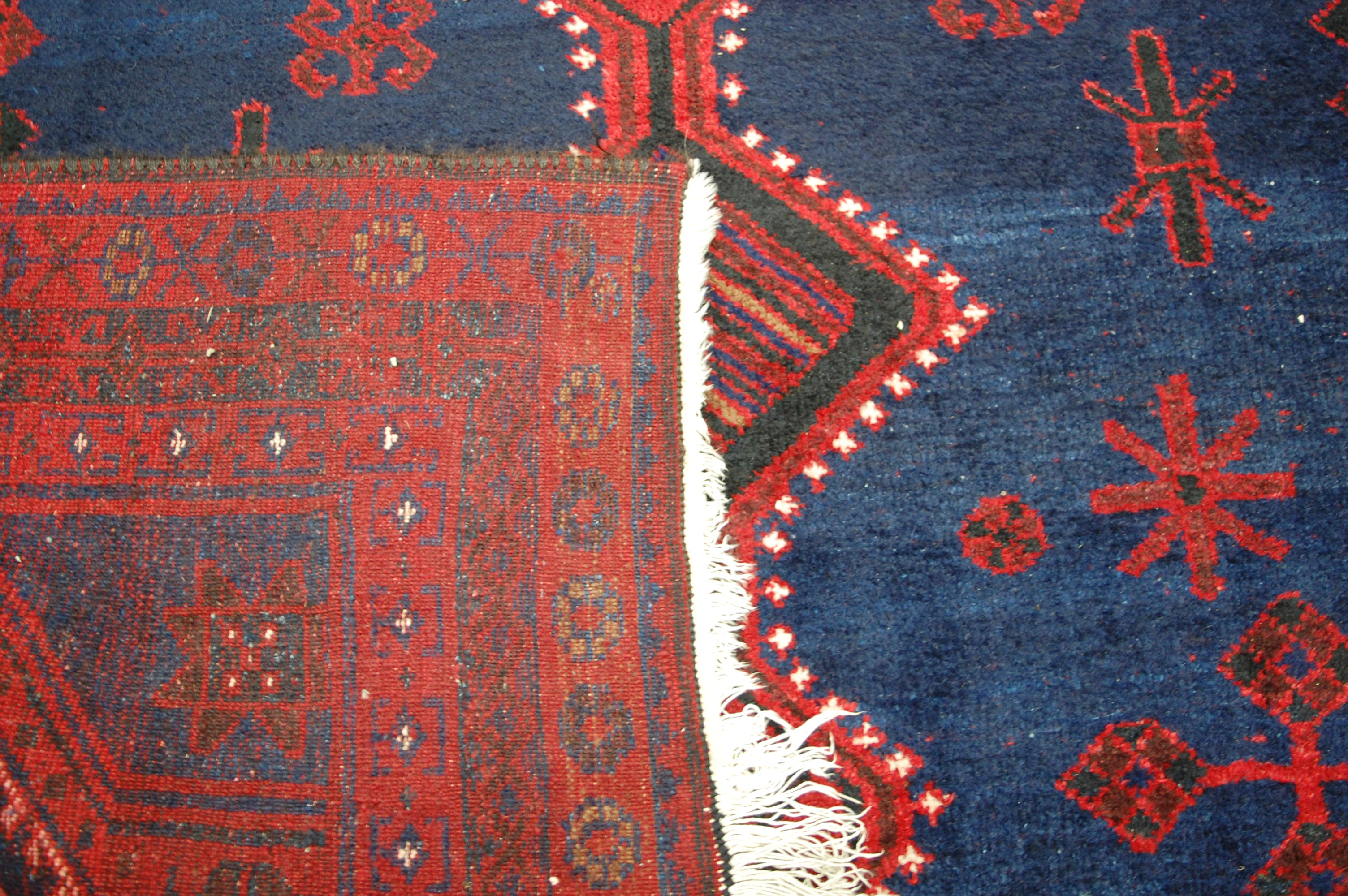 A Kurdish woollen rug, the blue ground decorated with graduated link medallions, - Bild 3 aus 3