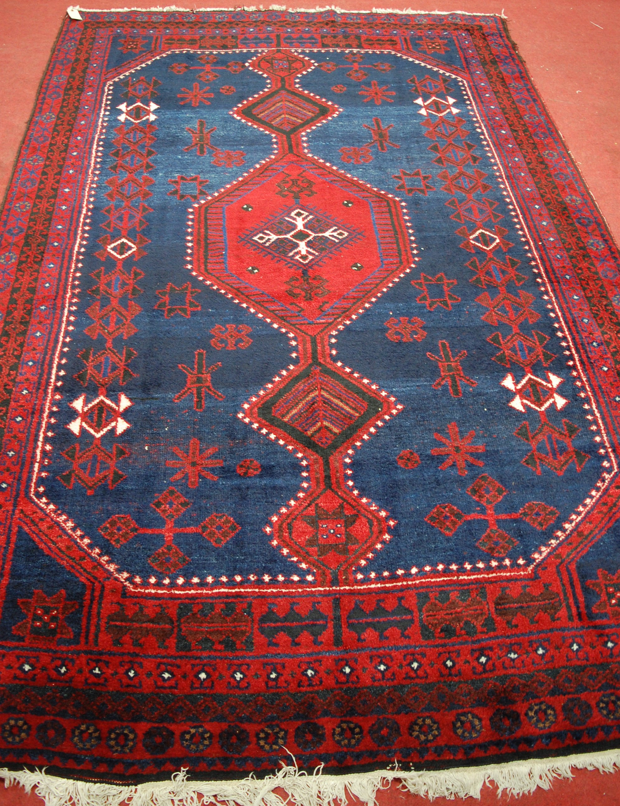 A Kurdish woollen rug, the blue ground decorated with graduated link medallions, - Bild 2 aus 3