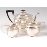 An Edwardian silver three-piece teaset, comprising teapot, twin handled sugar and cream,