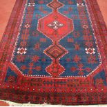 A Kurdish woollen rug, the blue ground decorated with graduated link medallions,