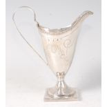 A George III silver pedestal cream jug, of helmet form, with bright cut engraved decoration, 3.